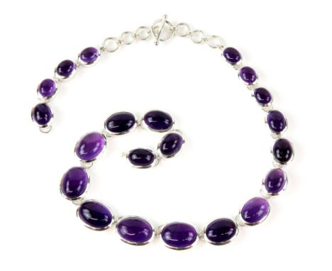 Amethyst set necklace, graduated oval cabochon amethysts, largest 1.8x1.2cm, set in silver, 'T' bar clasp, length 22cm.    