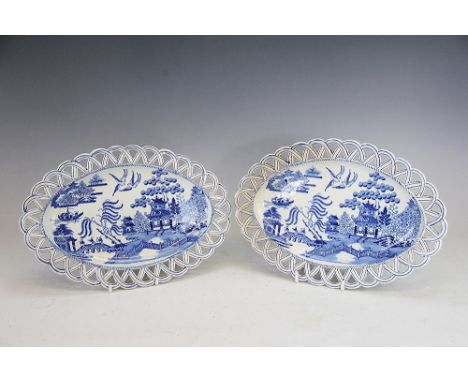 A pair of 19th century pearl ware blue and white oval dishes, possibly sauce tureen stands, decorated with a willow pattern s