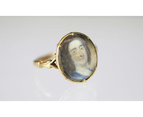 A portrait miniature ring, the oval ring depicting an 18th century gentleman wearing blue frock coat and white cravat, all se