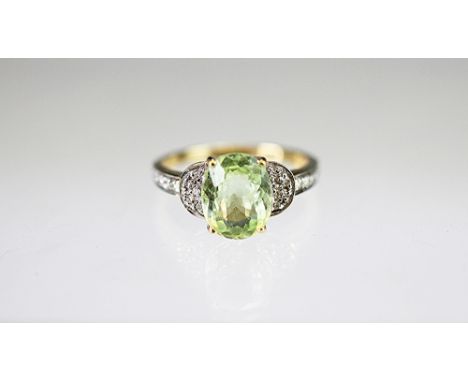 A paraiba tourmaline and diamond ring, the oval tourmaline within a diamond set surround all set in yellow and white metal st