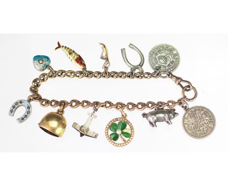 A yellow metal bracelet with attached charms, to include; a diamond set and enamelled horseshoe locket enclosing hair, engrav