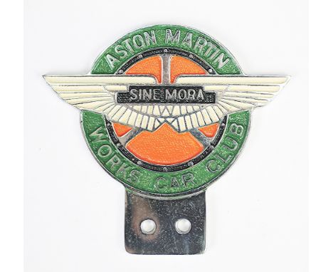 An Aston Martin works car club badge, Sine Mora, K6753, issued 1969, with cream wings against an orange ground and green surr