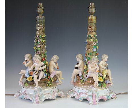A pair of Continental porcelain lamp bases, early 20th century, each modelled as a central column with climbing flowers, the 
