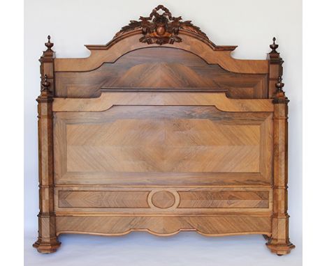 A late 19th century French carved kingwood and rosewood double bed, the headboard with carved and pierced bow tied surmount, 