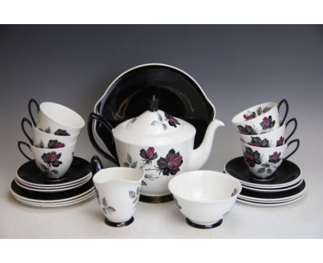 A Royal Albert Bone China tea service, decorated with black and red roses, to include; a teapot and cover, sugar bowl, milk j