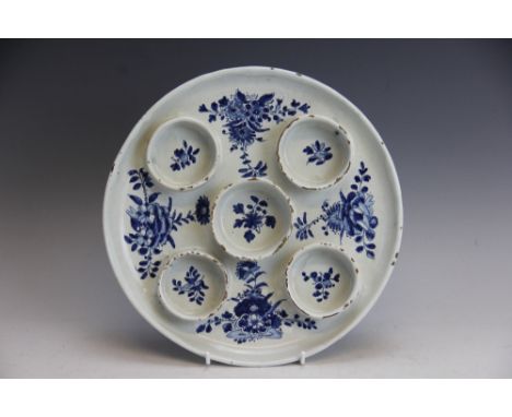 A delftware circular sweetmeat dish, 18th century, the circular tray with five integral 'wells', decorated with floral sprays