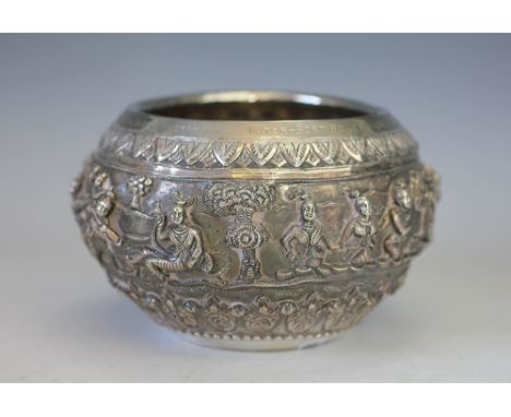 A Burmese silver bowl, early 20th century, the body embossed with a continuous procession of dancers with landscape beyond wi
