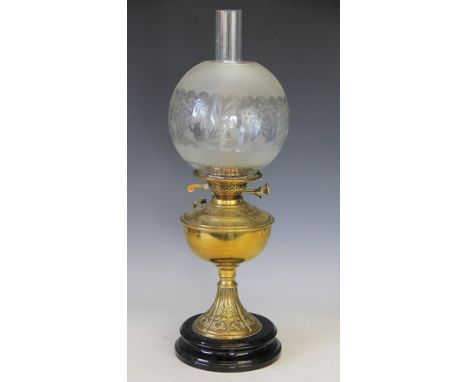 An Art Nouveau brass oil lamp circa 1900, of traditional design with heart embossed detail, foliate frosted shade and clear c