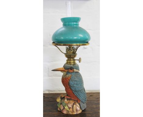 A German porcelain oil lamp in form of a kingfisher, decorated throughout with glass beads, with green glass shade; with an o