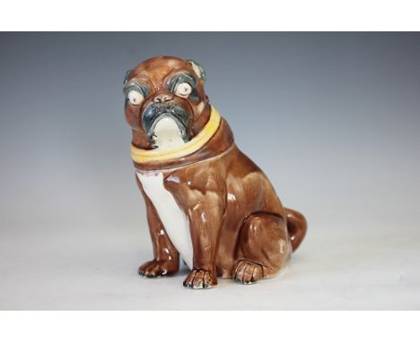 A Majolica tobacco jar and cover modelled as a pug, 19th century, the dog modelled seated with pink glazed interior, yellow c