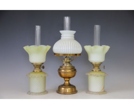 A pair of glass oil lamps and shades, each of wrythen moulded yellow opaque glass, with clear glass trailed decoration and cl