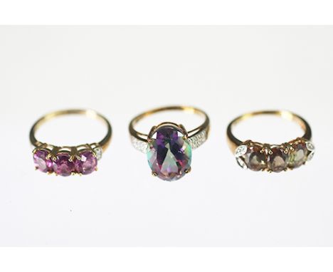 Three rings, to include; a mystic topaz set ring, the central topaz with diamond set shoulders, all set in 9ct yellow gold, a