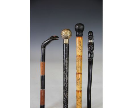 Four walking canes, comprising a Japanese carved and engraved bone cane with faux bamboo handle, 88cm, a sectional hardwood s