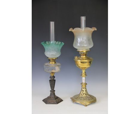 A Victorian brass oil lamp, with cast and pierced spreading base, peach tinted, crimped shade and clear glass chimney 70cm hi