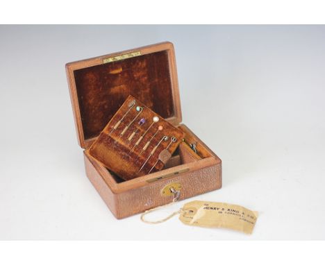 A jewellery box containing a collection of assorted stick pins, to include; an enamelled flower head along with garnet, coral