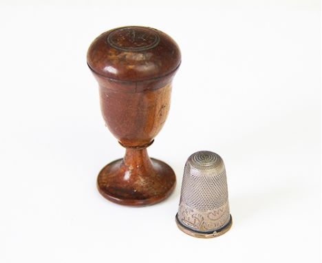 A treen thimble case enclosing thimble, the turned case of urn form, enclosing thimble engraved 'Victoria Our Hope', case 5cm