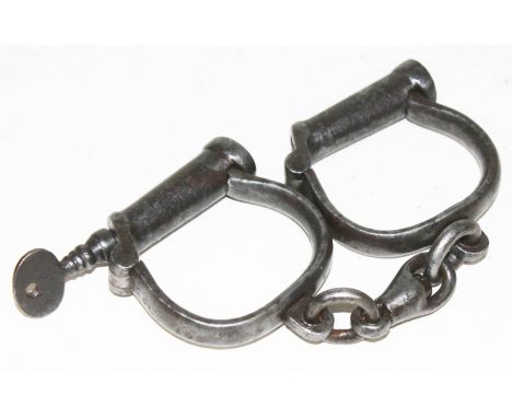 A pair of Hiatt WWI military handcuffs, stamped 'Hiatt and 'M&amp;C 1917' and also stamped with broad arrow, complete with ke