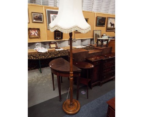 A mid-20thC standard lamp with turned fluted supports and circular base 