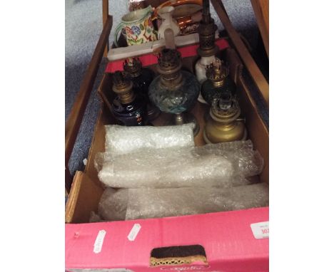 Seven early 20thC ceramic glass and brass oil lamps