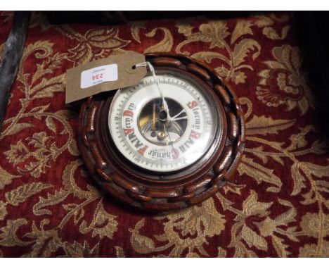A 1930s oak cased aneroid barometer with chain link border