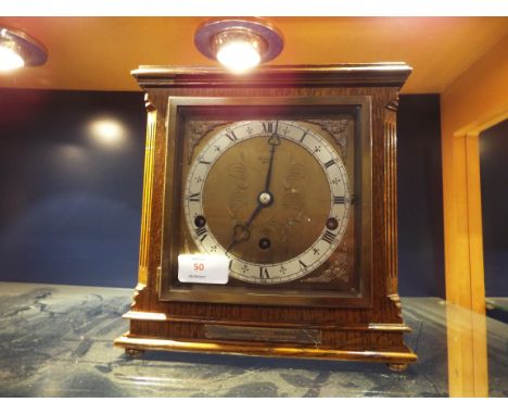 An oak cased Elliot mantle clock having brass and silvered dial with Roman numerals, eight day movement with Westminster chim