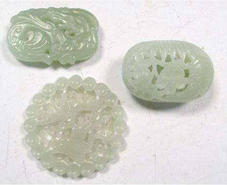 Three various nephrite jade pendants, the hollowed and flattened egg shape of the first pierced and carved with birds amongst