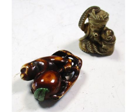 A monkey and peach ivory netsuke and an octopus and monkey netsuke, the first stained brown, the supporting leaf inset with a