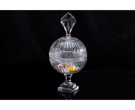 A CRYSTAL JAR WITH MURANO ART GLASS CANDY
A rounded crystal urn jar with cut fluted sides, large faceted finial and tiered sq