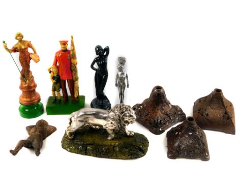 A hollow metal figure of a standing lion, on naturalistic rock work base and four various spelter type figures, to include la