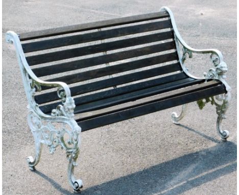 A 20thC slatted garden bench, with scroll arms, mask heads to the front and scroll feet, 80cm H, 127cm W, 69cm D.