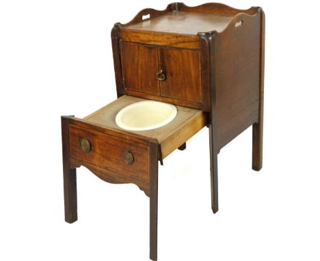 A George III mahogany night commode, with galleried top raised above double cupboard and partial pull out commode, on angle s