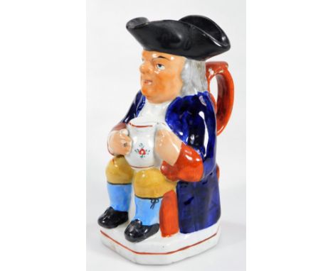 A Victorian Staffordshire pottery Toby jug, seated holding a foaming jug of ale and pipe wearing jacket, neckerchief, waistco