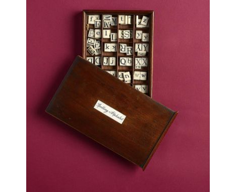 Games: An ivory spelling alphabet in a wooden box  circa 1900 the box 15cm.; 6ins high by 25cm.; 10ins wide