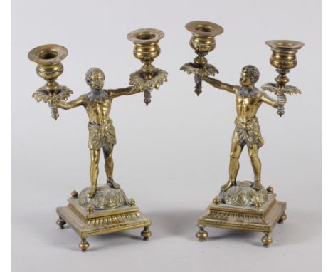 A pair of 19th century brass Nubian figure two-light candlesticks, on square bases, 9" high 