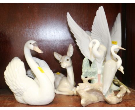 A Lladro fawn, 6 1/2" high, a Lladro turtledove, 11" high, a Lladro swan, 7" high, and a Nao heron group, 10" high