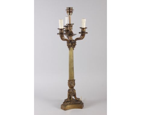 A 19th century brass four-light table candelabra with rams heads on triform base (now converted to electricity), 28" high