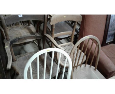 An elm seated elbow chair; two stick back kitchen chairs and a cane seated chair