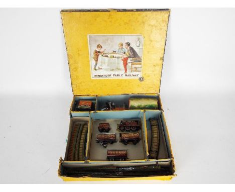 Bing - A boxed OO gauge Bing Miniature Table Railway Set 5. The set contains a clockwork 2-4-0 steam locomotive and tender in