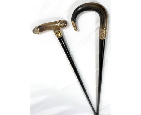 A 19th Century horn-handled stick with gilt metal mounts and ebony shaft, 88cm, and a similar stick (2).