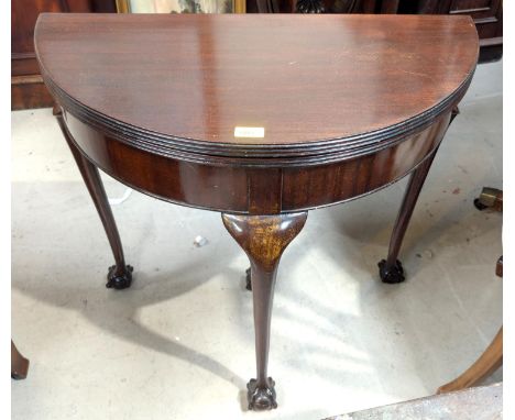 A mid-20th Century Georgian-style mahogany fold-over card table on cabriole legs and ball and claw feet.