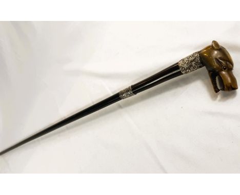 A 19th Century ebonised walking stick with silver mounts and carved horn handle of an angry dog, 94cm.