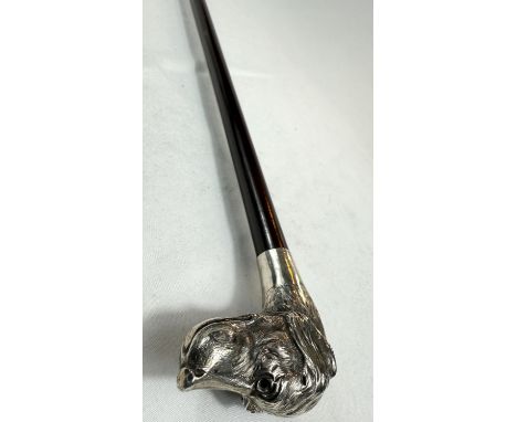An Edwardian walking stick with hardwood shaft and silver dog's head finial (eyes missing), London, 1905, 87cm.