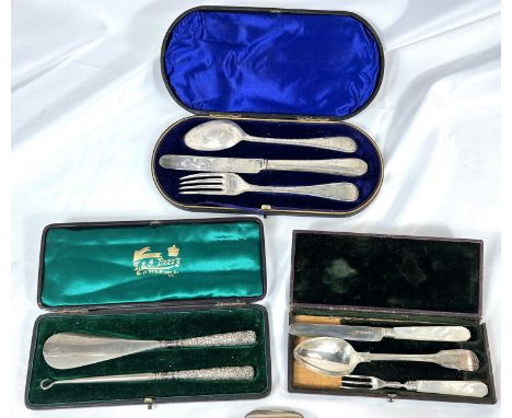 Two cased hallmarked silver three piece christening sets; a cased shoe horn and button hook + a plated sovereign holder.