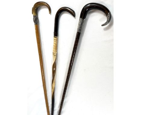 Two vintage horn-handled sticks with white metal mounts, 91cms, and a twisted horn stick (3).