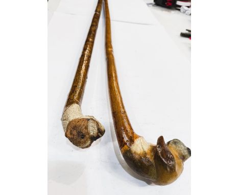 A 20th Century staff by C. Warriner with painted dog's head finial, 125cm, and a similar stick (2).