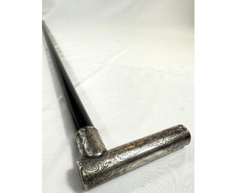A 19th Century ebonised walking stick with tubular handle encased in silver with scrollwork engraving, 92cm.