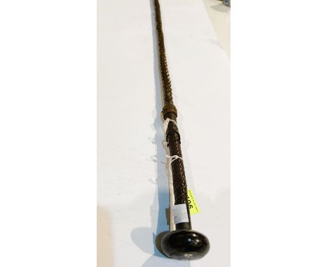 A 19th Century Spanish stick with plaited leather handle concealing a spike, the button finial inset enamel disc, engraved 'E