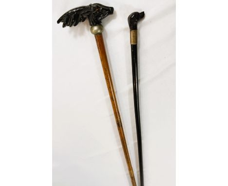 A 19th Century swagger stick with ebonised shaft and carved dog finial, 77cm, and another stick with deer finial, 93cm (2).