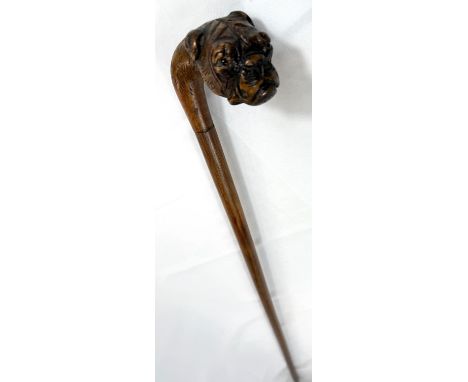 A vintage walking stick with cane shaft and carved wood dog's head handle, 90cm.