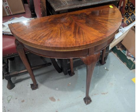 A mahogany demi-lune card table with quartered crossbanded decoration, inlaid green baize surface and cabriole legs with ball